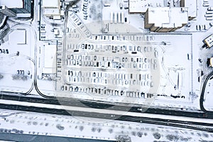 Outdoor parking lot in suburb district with parked cars at winter time. aerial view