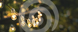 Outdoor party string lights hanging in backyard on green bokeh background