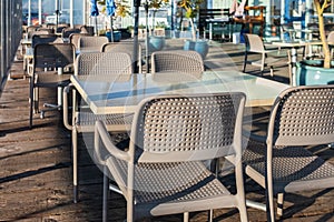 Outdoor patio chair and table in cafe restaurant. Empty street restaurant summer terrace with tables and chairs