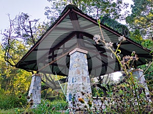 Outdoor patio pergola shade structure made of stones and metal roof top at a garden. Dehradun city India