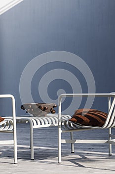 Outdoor patio terrace grey metal furniture on wooden deck. Cozy patio area with garden furniture.