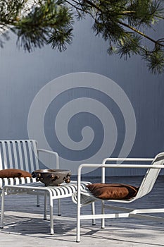 Outdoor patio terrace grey metal furniture on wooden deck. Cozy patio area with garden furniture.