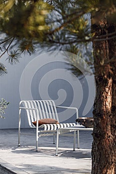 Outdoor patio terrace grey metal furniture on wooden deck. Cozy patio area with garden furniture.
