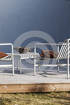 Outdoor patio terrace grey metal furniture on wooden deck. Cozy patio area with garden furniture..
