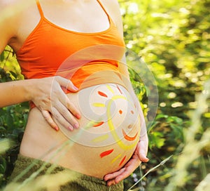 Outdoor picture of a pregnant woman abdomen with drawing