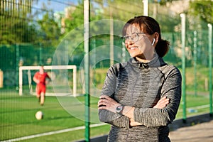 Outdoor portrait of active smiling middle aged woman, copy space