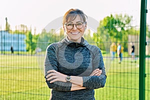 Outdoor portrait of active smiling middle aged woman looking at camera