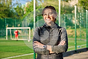 Outdoor portrait of active smiling middle aged woman looking at camera