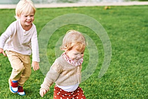 Outdoor portrait of adorable happy children playing together next to lake or river