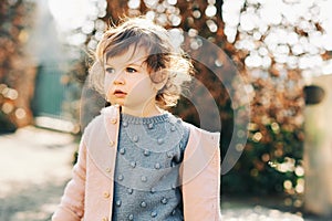 Outdoor portrait of adorable toddler girl with curly hair