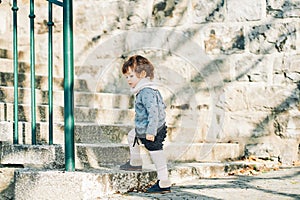 Outdoor portrait of adorable toddler girl with curly hair