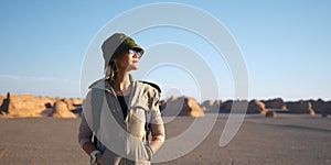 Asian woman female tourist backpacker with yardang landforms at sunset photo