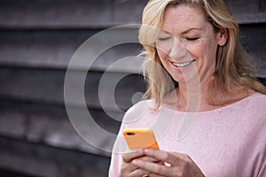 Outdoor Portrait of Attractive Middle Aged Woman Using Cell Phone