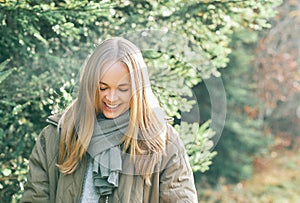 Outdoor portrait of beautiful blond woman, looking down