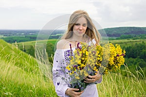 Outdoor portrait of beautiful blonde woman, attractive young girl in camomile field with flowers. Young beautiful girl in the fiel