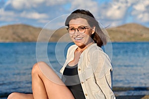 Outdoor portrait of beautiful smiling middle aged woman looking at camera