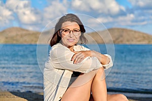 Outdoor portrait of beautiful smiling middle aged woman looking at camera