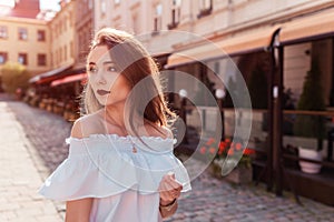 Outdoor portrait of beautiful stylish woman walking on street. Fashion model wearing summer clothing and accessories