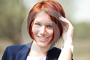 Outdoor portrait of beautiful woman with red hair