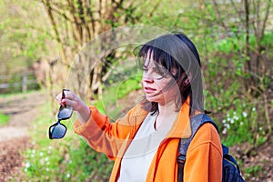 This outdoor portrait captures the beauty and confidence of a young woman wearing a backpack and sunglasses.