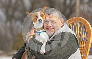 Outdoor portrait of Caucasian senior man with his cute basenji dog