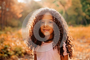 Outdoor portrait of a cute afro american happiness little girl with curly hairl.