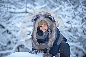 Outdoor portrait of cute baby kid in cold sunny winter weather in park. Childhood memories - beautiful snowy winter over