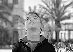 Outdoor portrait of a cute litlle boy who looking up