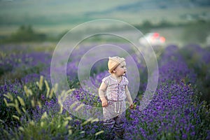 Outdoor portrait of a cute little child, a baby or toddler girl with her dog, a yellow labrador sitting on the ground in