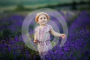 Outdoor portrait of a cute little child, a baby or toddler girl with her dog, a yellow labrador sitting on the ground in