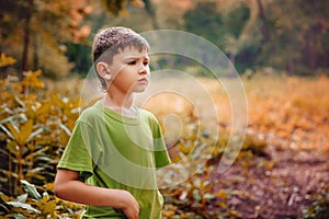 Outdoor portrait of a cute serious boy.