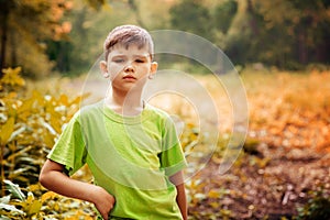 Outdoor portrait of a cute serious boy.
