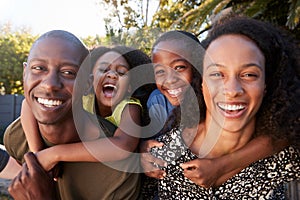 Outdoor Portrait Of Family In Garden At Home Against Flaring Sun