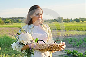 Outdoor portrait of farmer woman with basket of fresh chicken eggs, farm