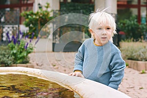 Outdoor portrait of happy and active toddler boy