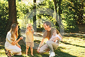 Outdoor portrait of happy family having fun in summer park