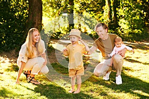 Outdoor portrait of happy family having fun in summer park