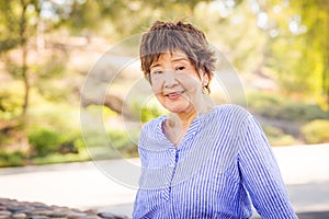 Outdoor portrait of a happy senior adult Chinese woman