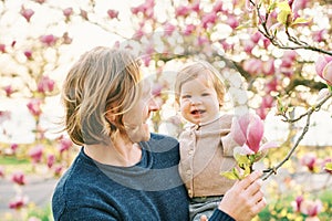 Outdoor portrait of happy young father playing with adorable toddler girl