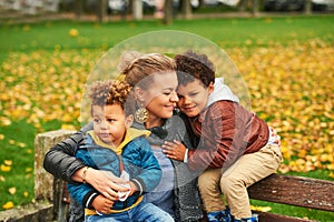 Outdoor portrait of happy young mother with two lovely sons