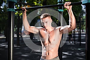 Outdoor portrait of healthy handsome active man with fit muscular body, sports and fitness concept