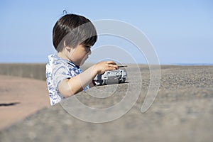Outdoor portrait of little boy looking out with thinking face, Child playing outdoor activity