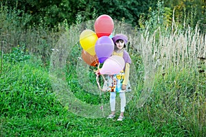Outdoor portrait of little girl with balloons