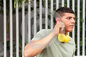 portrait of a man with freckles, enjoying a cell phone conversation while standing in the city park