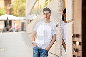 Outdoor portrait of modern attractive young man in the city. Urban background