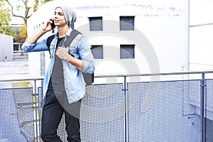 Outdoor portrait of modern young man with mobile phone in the st
