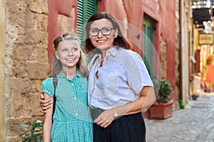 Outdoor portrait of mom and daughter 10, 11 years old on the street of old city