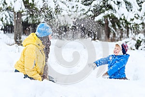 Outdoor portrait Mother and child playing in the winter park. showered with snow