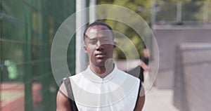 Outdoor portrait of motivated african american basketball player coming to camera
