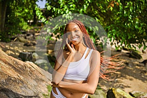 Outdoor portrait of natural Beautiful young African American woman long red braids hair style and perfect white teeth